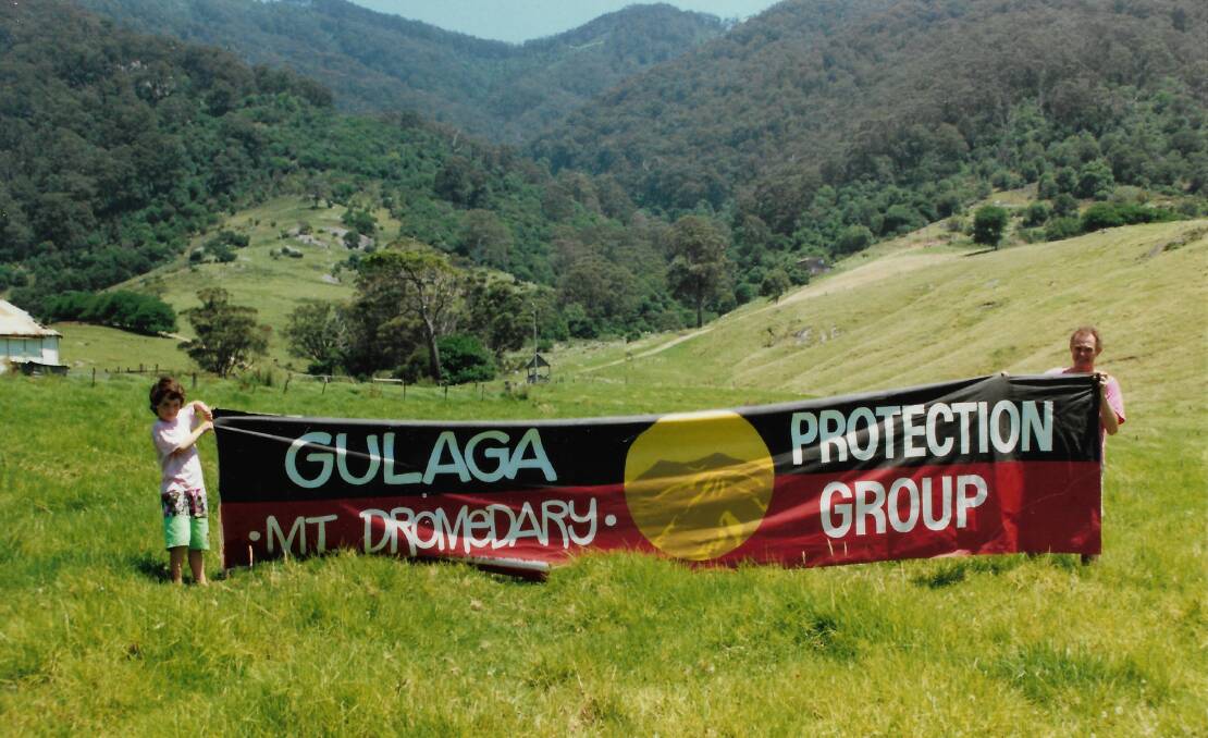 Sean Burke and his son Oliver with the banner in front of Gulaga. Picture supplied